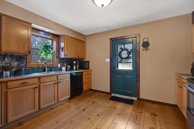 a kitchen with granite countertop wooden floors and white stainless steel appliances