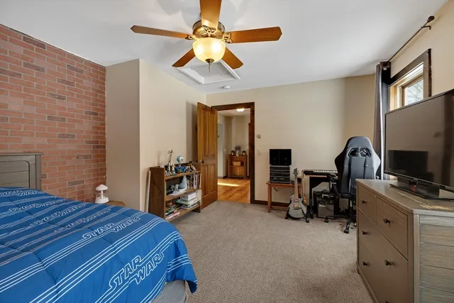a bedroom with a bed and a flat tv screen on the dresser