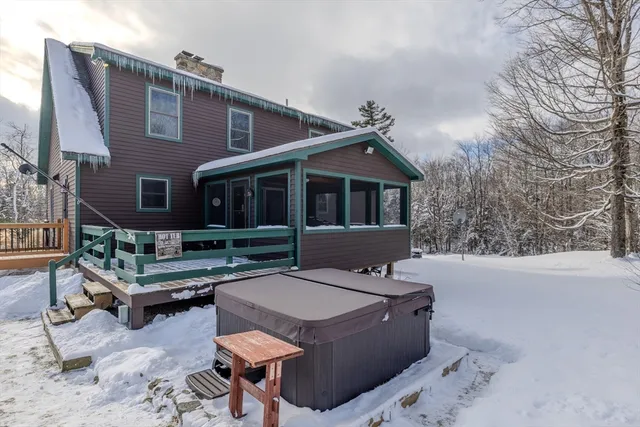 a view of a roof deck with couches and wooden fence
