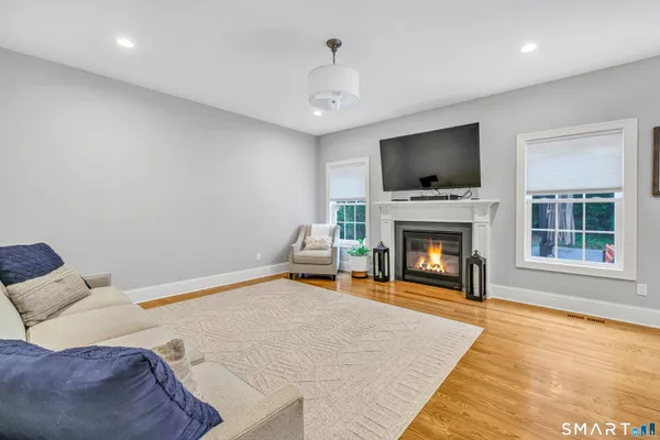 a living room with furniture a flat screen tv and a fireplace