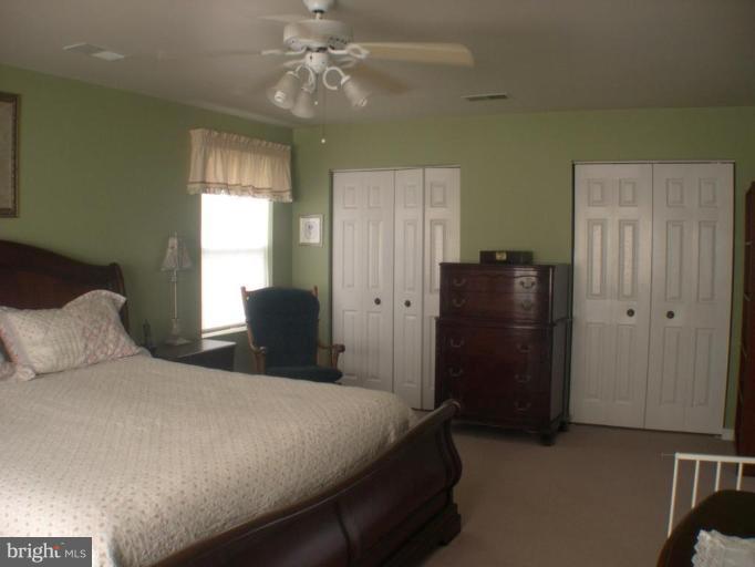 3202 Atlee Ridge Road New Windsor, MD 21776 - Photo 6 of 19 a bedroom with a bed and a chandelier