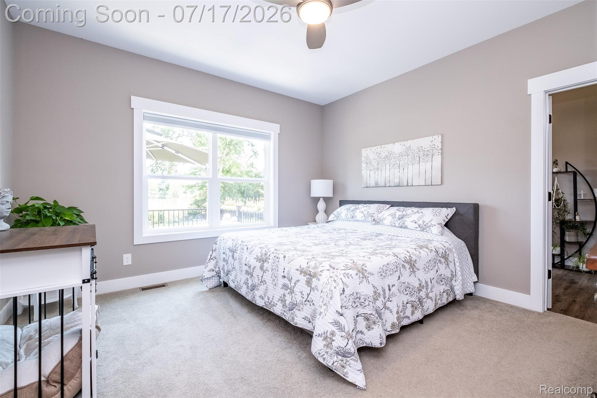 12349 Sugar Maple Drive Fenton, MI 48430 - Photo 23 of 67 Neutral-toned bedroom featuring a ceiling fan with integrated lighting, a large window with white trim, and light-colored carpeting