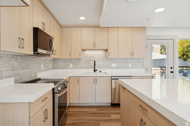 254 North Main Street Bountiful, UT 84010 - Photo 8 of 45 Kitchen with light brown cabinetry, stainless steel appliances, light wood-type flooring, recessed lighting, and tasteful backsplash