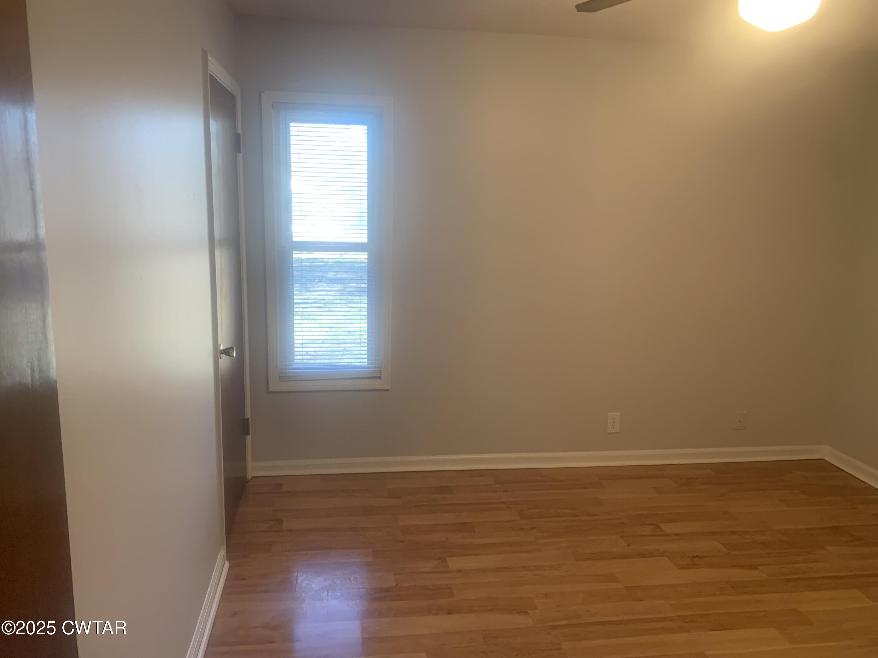72 Laneview-Concord Road Trenton, TN 38382 - Photo 14 of 39 a view of an empty room with wooden floor and a window