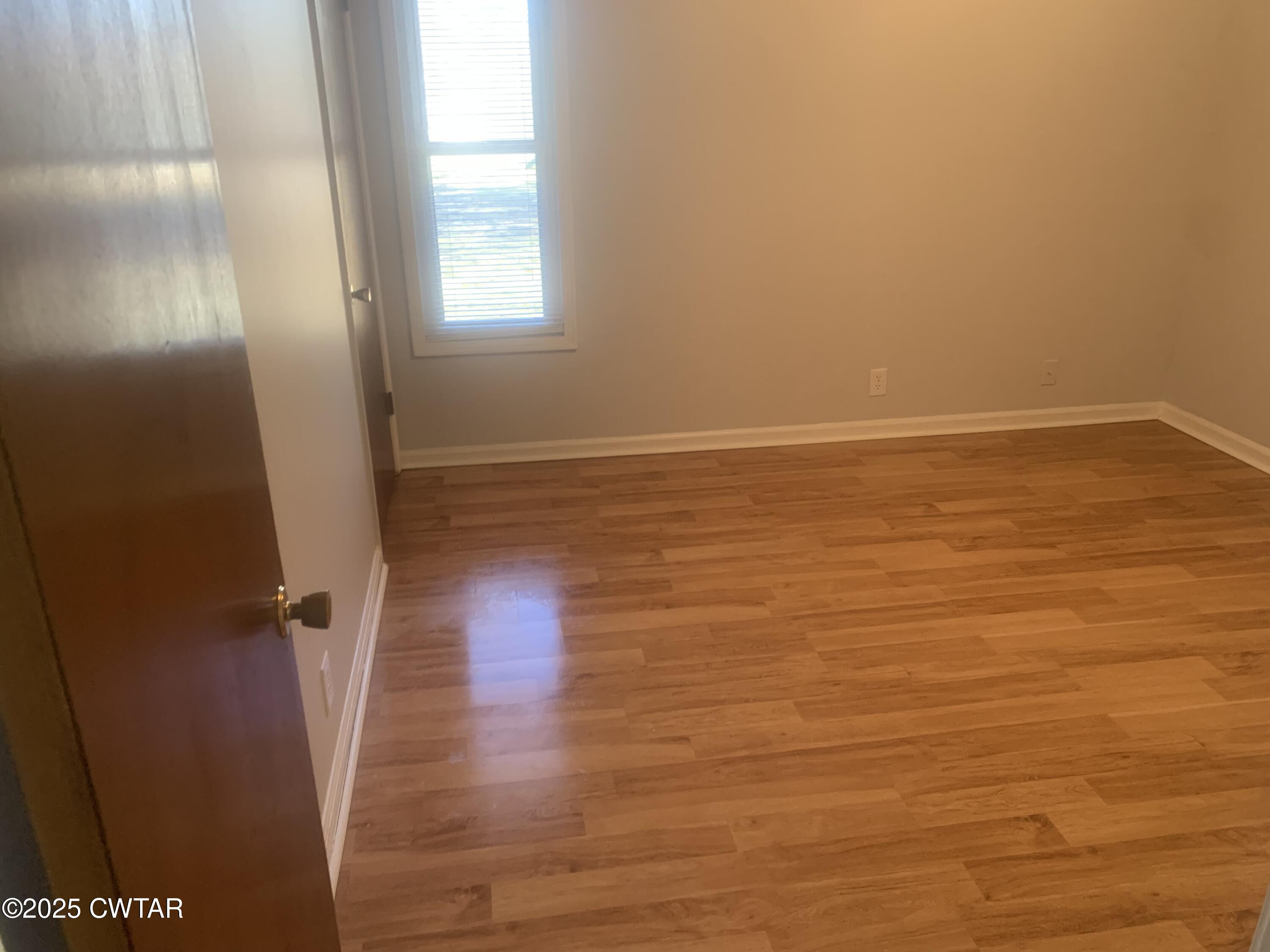 72 Laneview-Concord Road Trenton, TN 38382 - Photo 15 of 39 a view of an empty room with wooden floor and a window