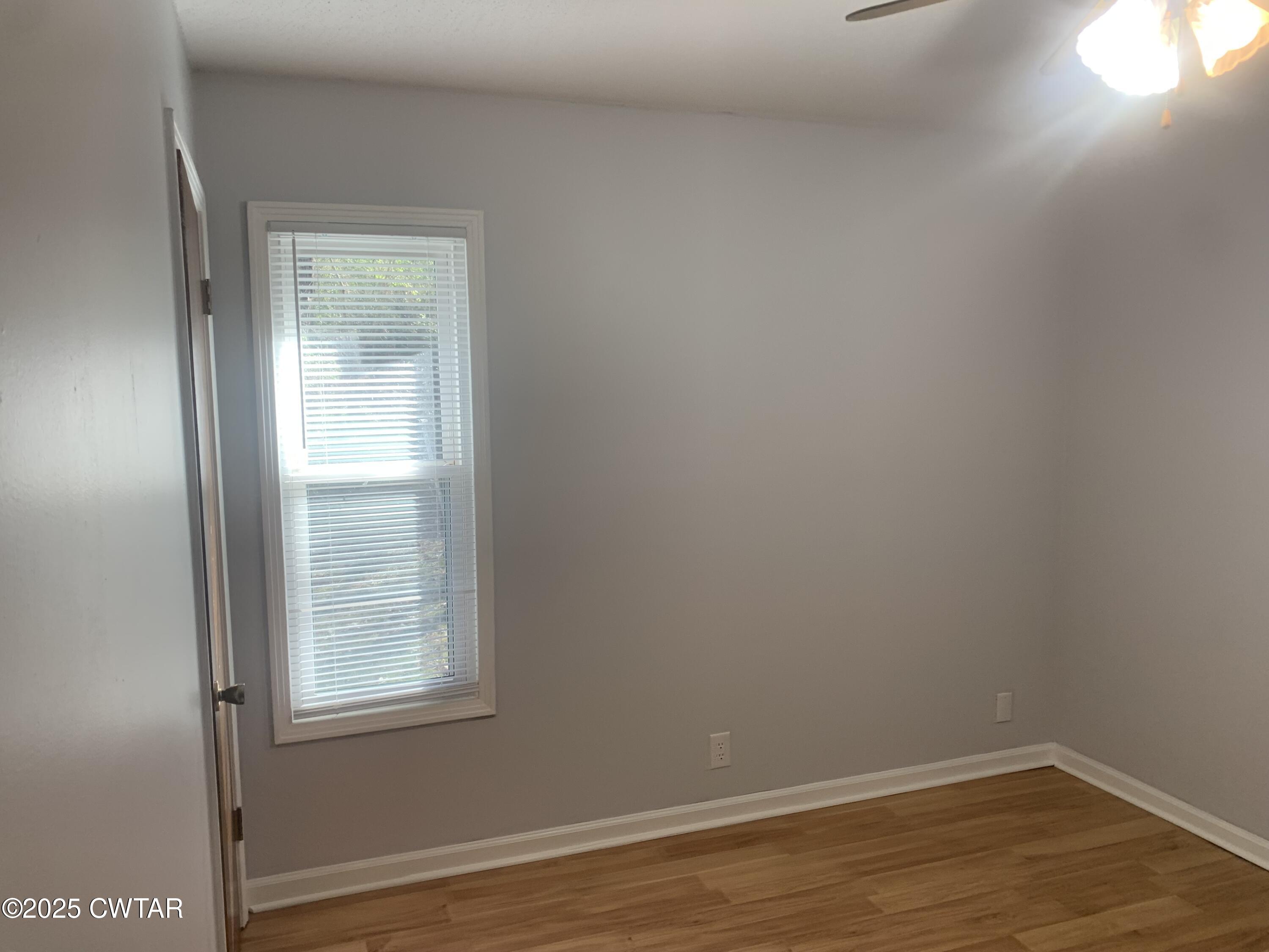 72 Laneview-Concord Road Trenton, TN 38382 - Photo 21 of 39 an empty room with wooden floor and windows