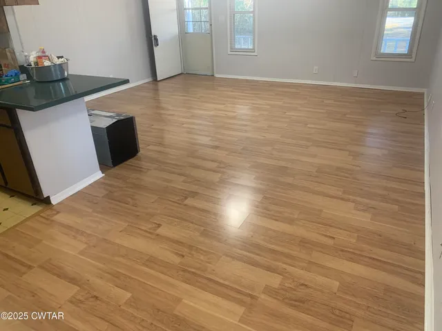 a view of empty room with cabinet and window