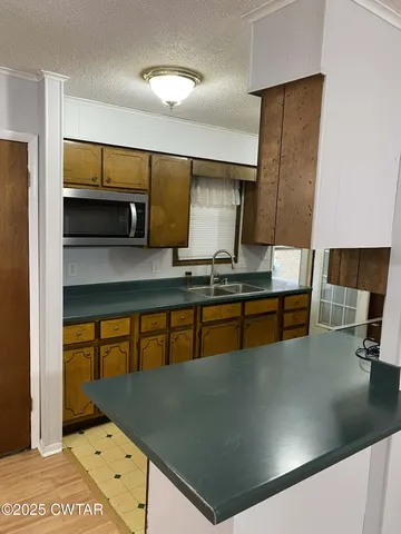 a kitchen with stainless steel appliances granite countertop a sink a stove and a refrigerator