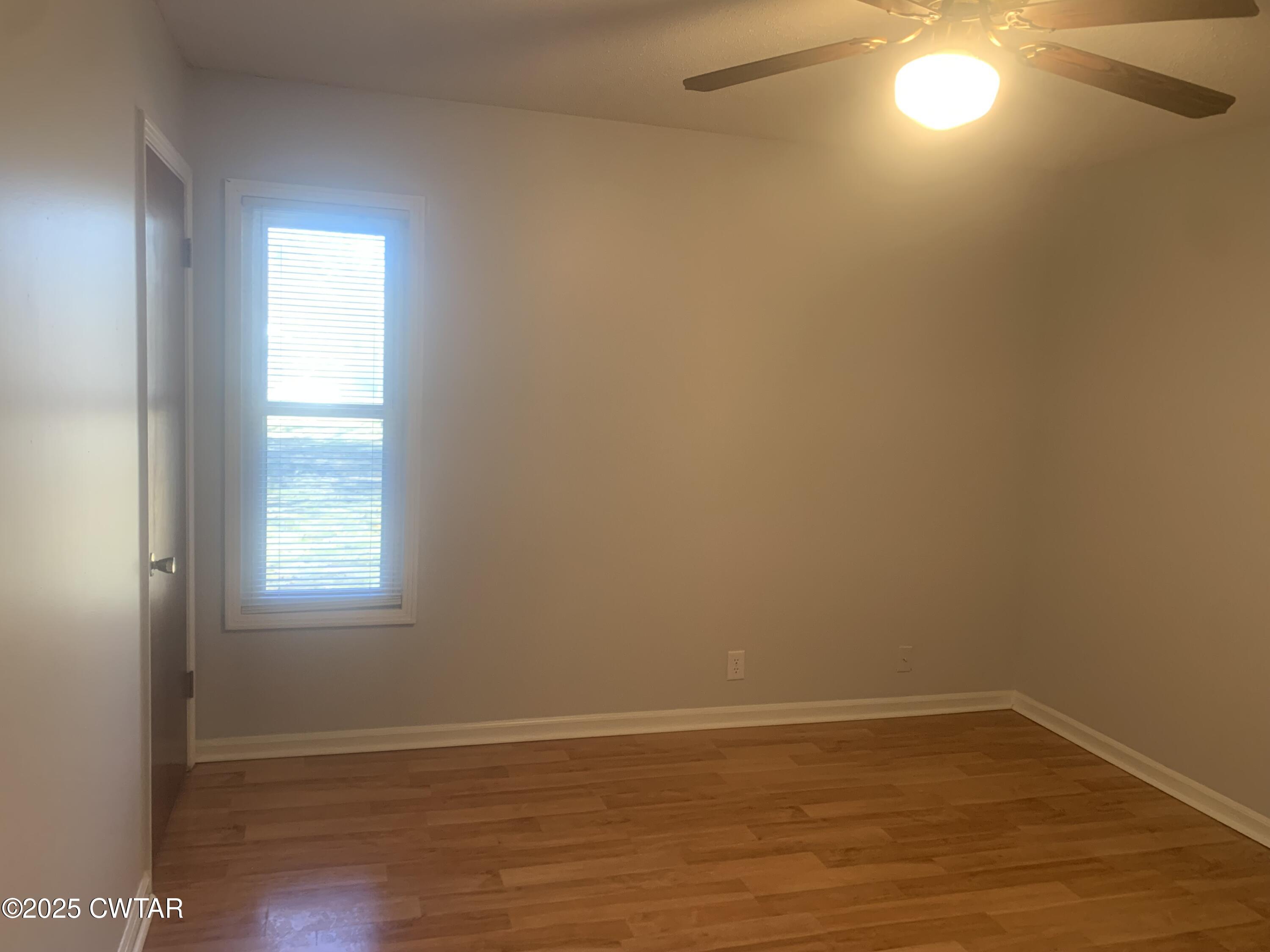 72 Laneview-Concord Road Trenton, TN 38382 - Photo 9 of 39 an empty room with wooden floor and windows