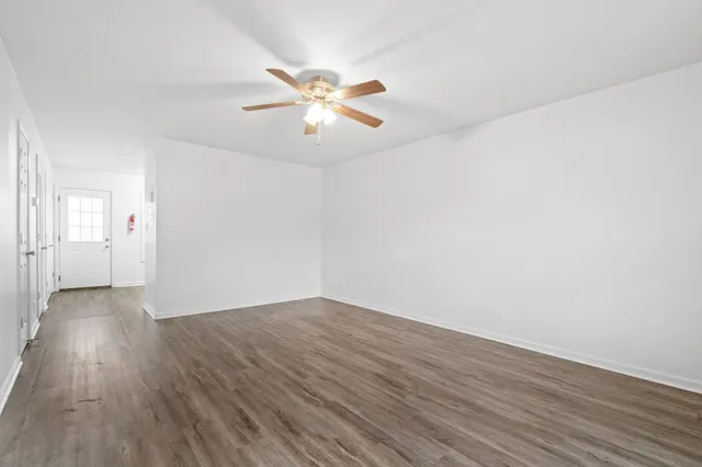 a view of an empty room with wooden floor