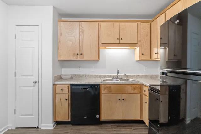 a kitchen with granite countertop stainless steel appliances a stove refrigerator and cabinets