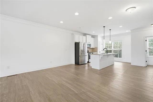a kitchen with stainless steel appliances a microwave a sink and a refrigerator