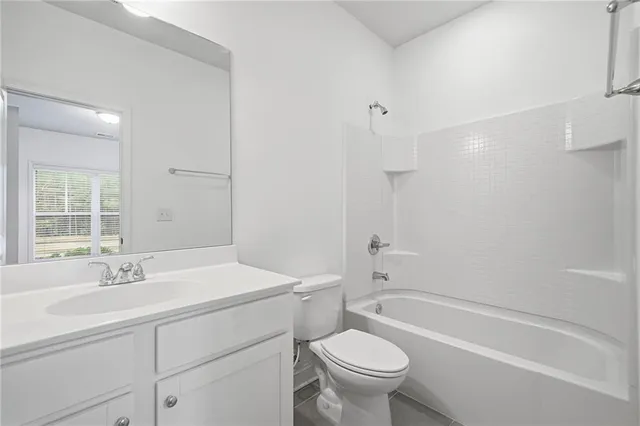 an empty room with wooden floor fireplace and windows