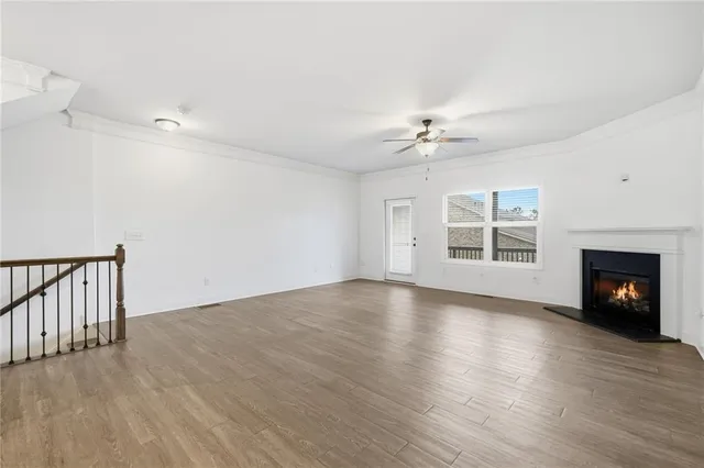 a view of empty room with wooden floor and fireplace