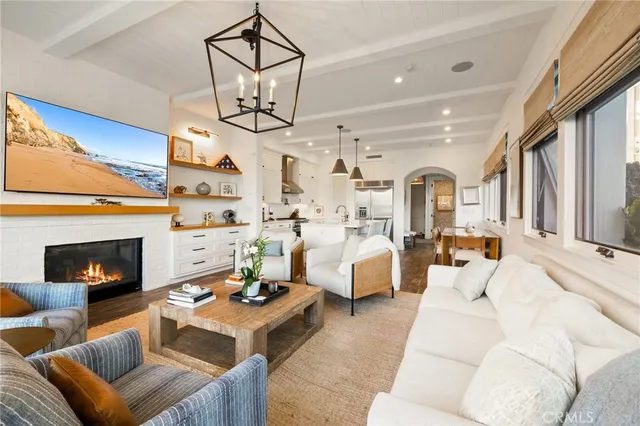 a living room with furniture a fireplace and a chandelier