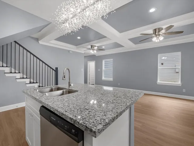 a kitchen with center island chandelier and living room view