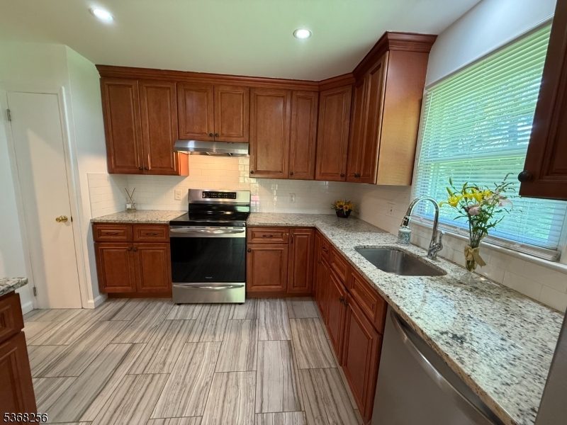 857 Cherry Hill Road Princeton, NJ 08540 - Photo 7 of 22 a kitchen with granite countertop wooden cabinets stainless steel appliances a sink and a large window