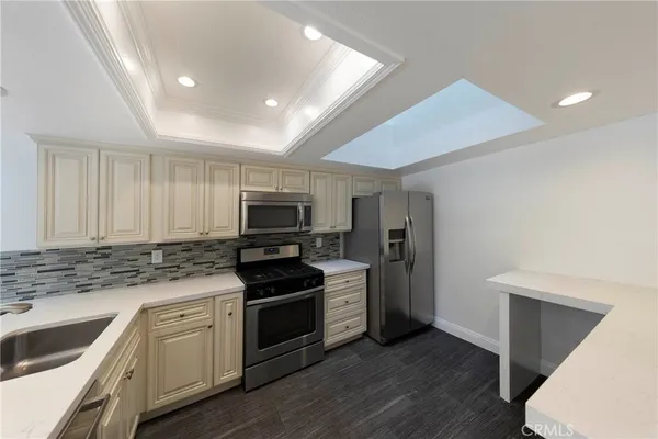 a kitchen with granite countertop a sink cabinets and stainless steel appliances
