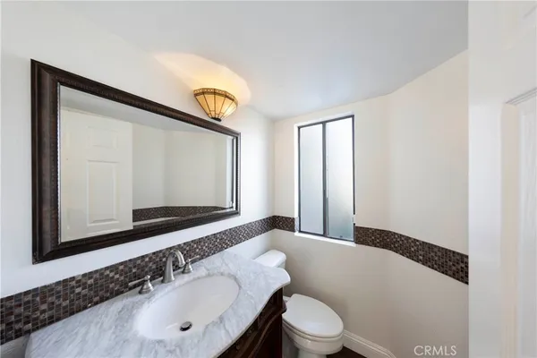 a bathroom with a sink a toilet and mirror