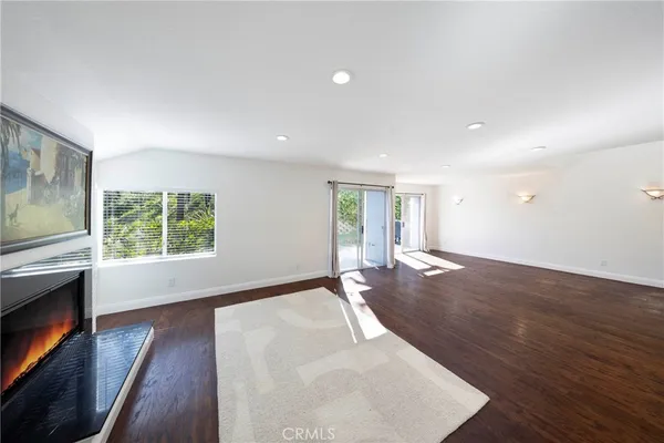 a view of empty room with wooden floor and fireplace