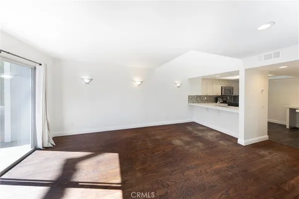 a view of kitchen with refrigerator and white cabinets