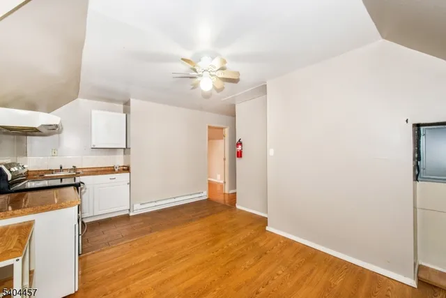 a view of a kitchen with wooden floor and a ceiling fan