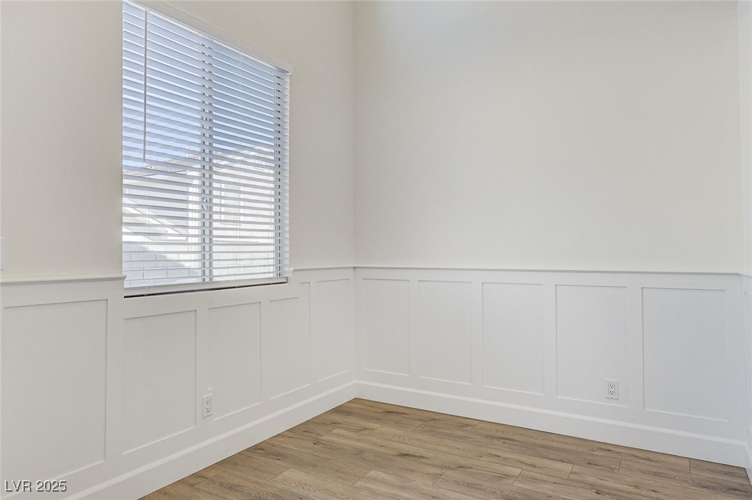 1995 Thunder Ridge Circle Henderson, NV 89012 - Photo 18 of 47 Spare room featuring light wood-type flooring, a decorative wall, and wainscoting