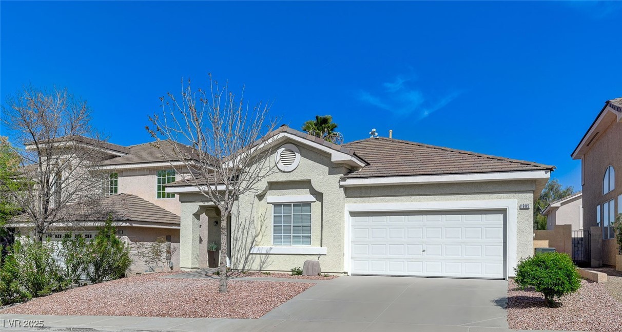 1995 Thunder Ridge Circle Henderson, NV 89012 - Photo 2 of 47 View of front of home featuring stucco siding, driveway, a garage, and a tile roof