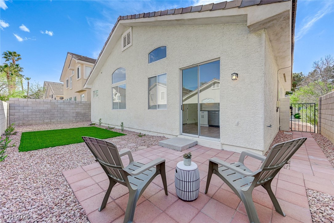 1995 Thunder Ridge Circle Henderson, NV 89012 - Photo 39 of 47 Rear view of property with fence private yard, a gate, stucco siding, and a patio