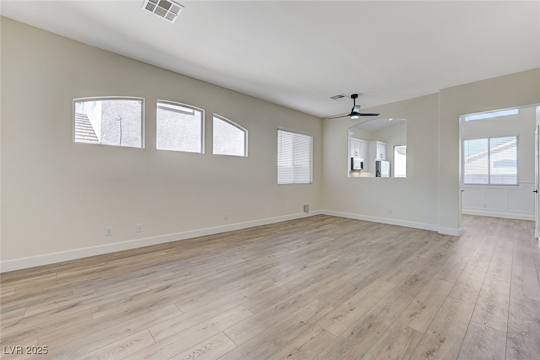 1995 Thunder Ridge Circle Henderson, NV 89012 - Photo 7 of 47 Unfurnished room with light wood finished floors, baseboards, visible vents, and ceiling fan