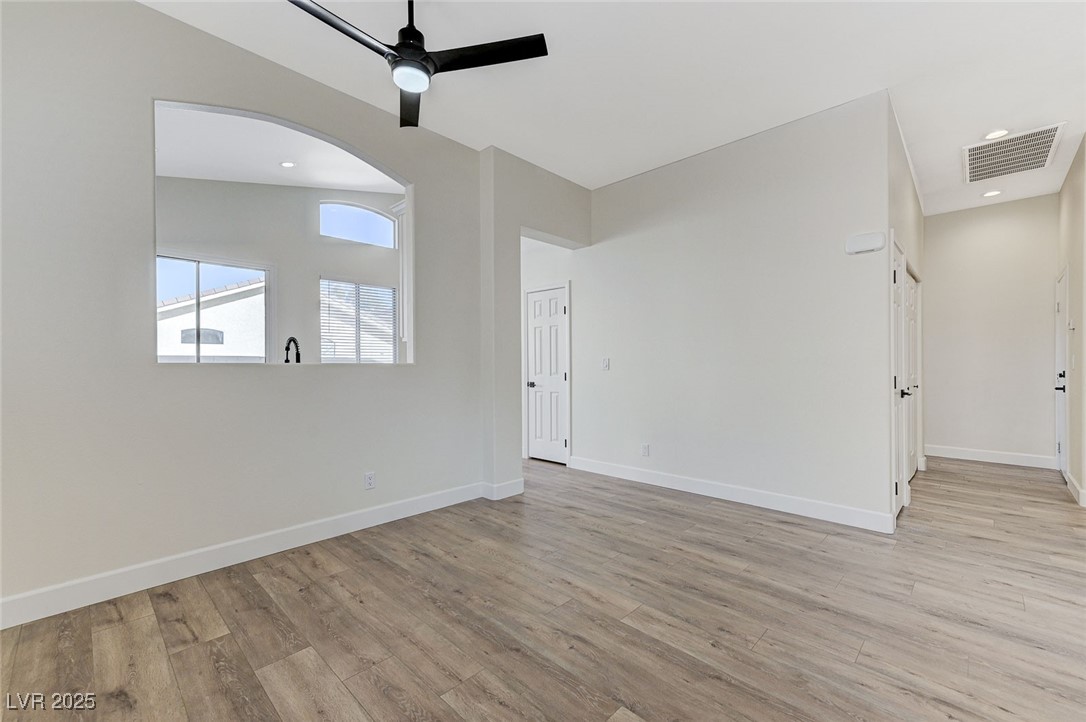 1995 Thunder Ridge Circle Henderson, NV 89012 - Photo 9 of 47 Unfurnished room featuring light wood-type flooring, baseboards, arched walkways, visible vents, and a ceiling fan