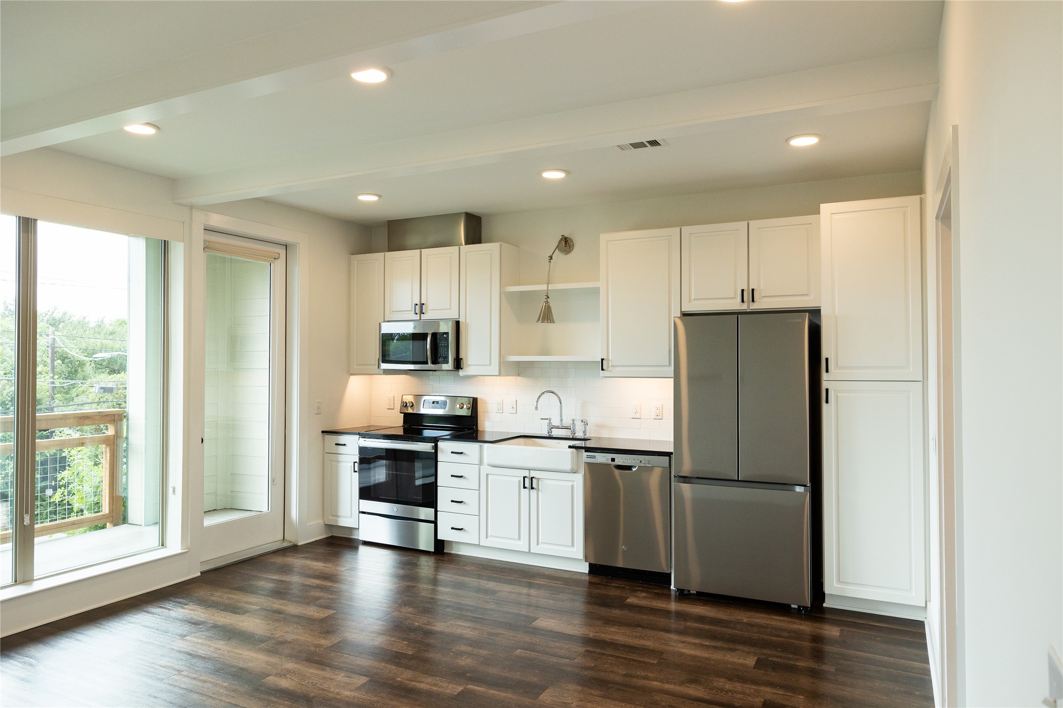 Kitchen featuring stainless steel appliances, white cabinets, open shelves, dark wood-type flooring, and recessed lighting