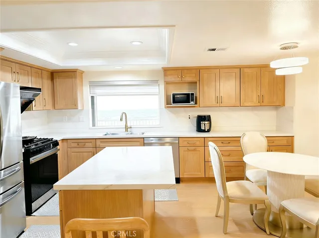 a kitchen with stainless steel appliances kitchen island granite countertop a sink and cabinets