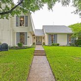 a front view of a house with a garden and yard