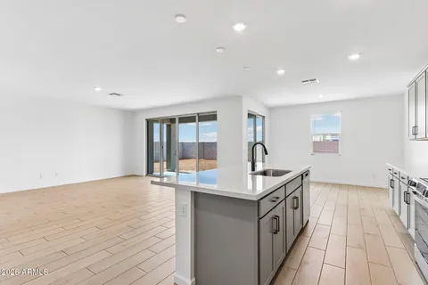 a kitchen with a sink and wooden floor
