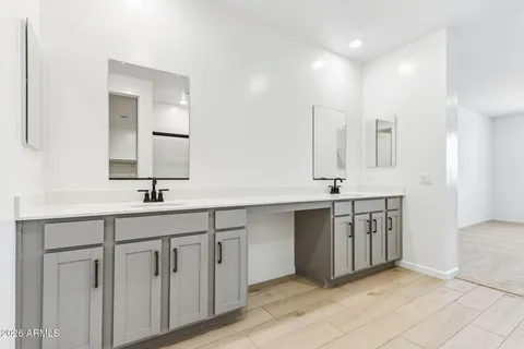 a spacious bathroom with a double vanity sink a mirror and a shower