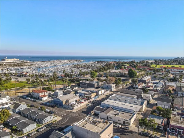 an aerial view of a city with ocean view in back