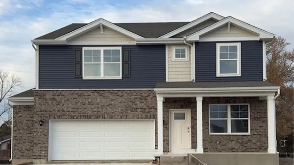 a front view of a house with yard and garage