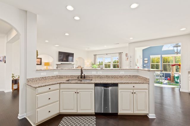 a kitchen with granite countertop a sink and white cabinets