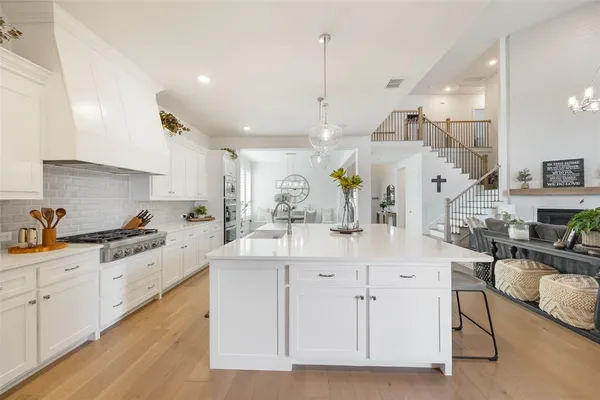 a large white kitchen with lots of counter space sink and appliances