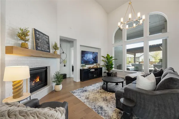 a living room with furniture a chandelier and a fireplace