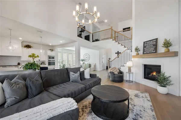 a living room with furniture a fireplace and a chandelier