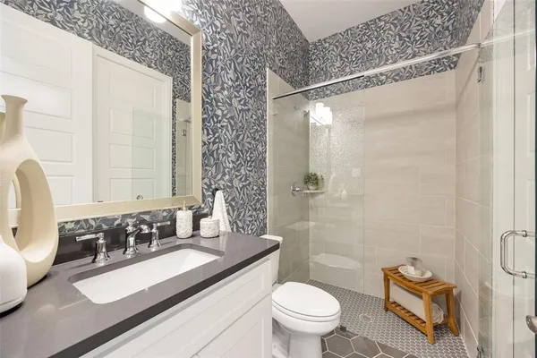 a bathroom with a granite countertop sink mirror vanity and toilet