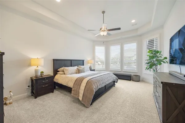a spacious bedroom with a large bed and a chandelier