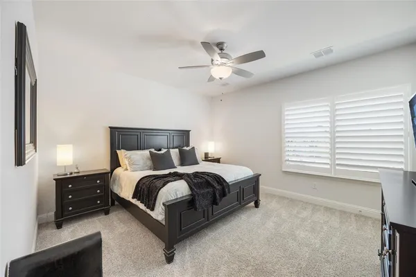 a spacious bedroom with a bed and a ceiling fan