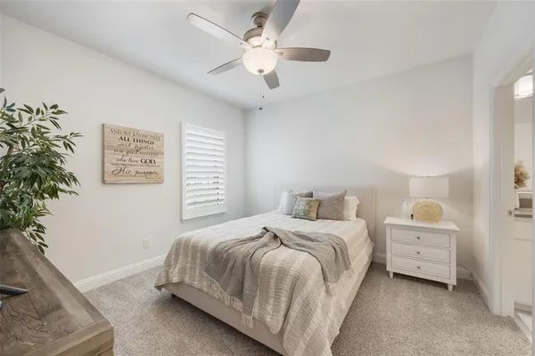 a bedroom with a bed dresser and a potted plant