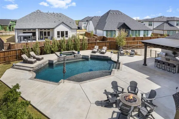 a view of a patio with couches table and chairs with wooden fence