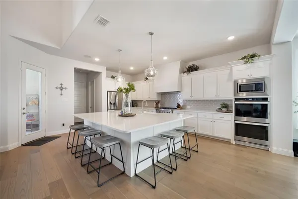 a kitchen with a table chairs microwave and cabinets