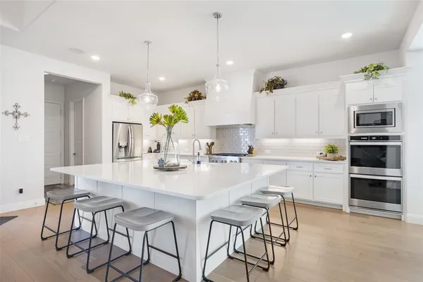 a kitchen with kitchen island a large counter top space appliances and cabinets
