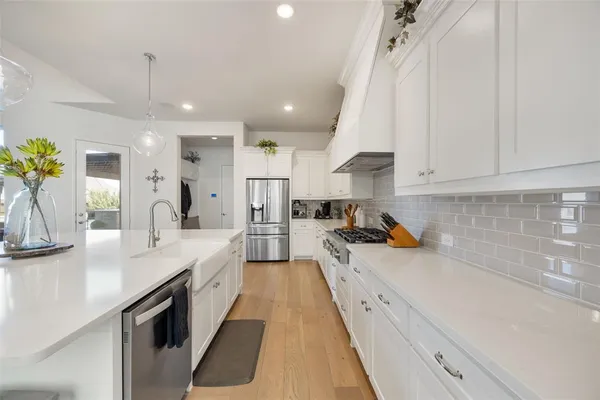 a large white kitchen with sink stove and refrigerator